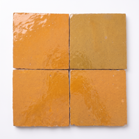 Close up of four Saffron Orange Zellige Square 4x4 tiles showing glaze variation
