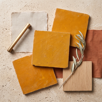 Saffron Orange Zellige Square 4x4 tiles styled on a designer mood board with linen, brass, and oak