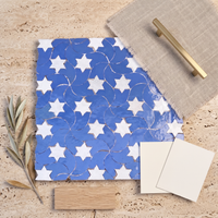 Star Swirl Zellige Mosaic Tile, Cornflower Blue & White, styled on a designer mood board with linen, brass, and oak