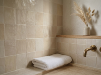 Linen Beige Zellige Square 4x4 on a handmade Moroccan bathroom wall with limewashed walls and travertine floor