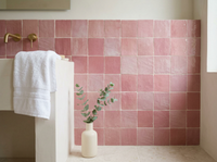 Peony Pink Zellige Square 4x4 on a handmade Moroccan bathroom wall with plaster walls and brass fittings